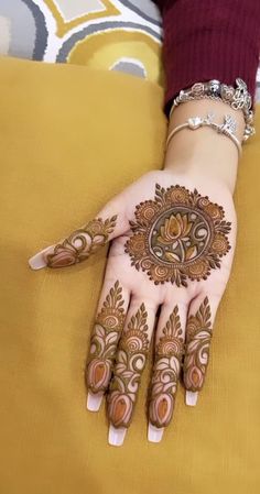 a woman's hand with henna tattoos on it