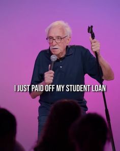 an older man holding a microphone in front of a purple background that says, i just paid off my student loan