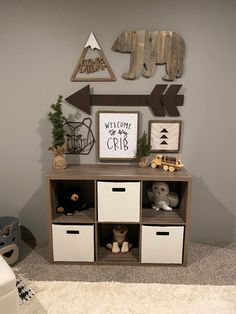 a teddy bear sitting on top of a wooden shelf next to a wall with signs