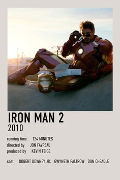 a man sitting on the ground talking on a cell phone while wearing iron - man costume