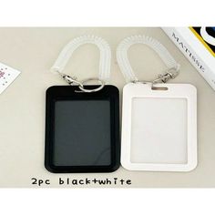 two black and white tags are sitting next to each other on a table with an ipod