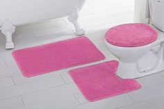 three pink bathroom rugs in front of a white toilet