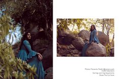 a woman sitting on top of a rock next to trees