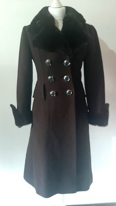 This stunning vintage women's '90s does '70s chocolate brown double-breasted overcoat is perfect for the winter.  Comes in a long-length A-line style Features: - double breasted  - faux fur cuffs & full collar - hip welt pockets - large navy blue squared buttons Condition: Immaculate condition Sizing: label reads 36, please ask for measurements before purchasing if you are unsure! Brown Double Button Closure Pea Coat For Winter, Brown Double Button Pea Coat For Winter, Brown Winter Pea Coat With Double Button Closure, Winter Brown Pea Coat With Double Button Closure, Brown Double-breasted Winter Pea Coat, Brown Double-breasted Pea Coat For Winter, Fitted Brown Long Pea Coat, Brown Buttoned Pea Coat For Winter, Brown Pea Coat With Buttons For Winter