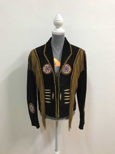 a black jacket with gold fringes on top of a mannequin's head