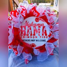 a red and white wreath with words on it