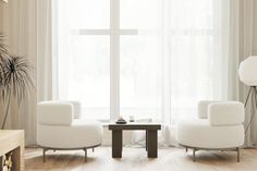 a living room with two white chairs and a coffee table in front of a large window