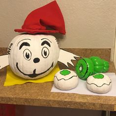 a dr seuss pumpkin sitting on top of a counter next to two green caterpillars