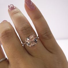 a woman's hand with a pink diamond ring on top of her left hand