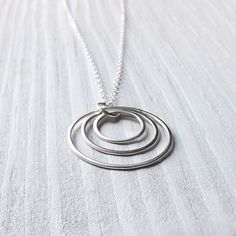 "This attractive geometric pendant comes with three hand crafted sterling silver rings. Each hoop size was hand formed and lightly cold forged, then sanded and polished to give them a soft shine. The rings range in size from the largest of one (1) inch to the smallest of 1/2 inch. The pendant comes on a 18\" sterling silver chain. K Davis Studios (ArtistiKat) jewelry always comes nicely packaged and ready for gift giving. Please feel free to visit the rest of my shop: http://www.etsy.com/shop/Ar Sterling Silver Circle Necklace For Mother's Day, Mother's Day Sterling Silver Circle Necklace, Mother's Day Circle Sterling Silver Necklace, Modern Full Circle Jewelry Gift, Sterling Silver Round Jewelry As Gift For Mom, Round Sterling Silver Jewelry For Mom, Modern Sterling Silver Jewelry For Mother's Day, Sterling Silver Hoop Necklace As A Gift, Modern Silver Jewelry For Mother's Day