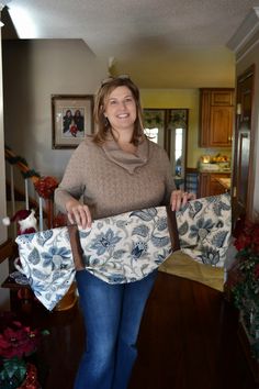 a woman is holding two pieces of fabric in her hands and smiling at the camera