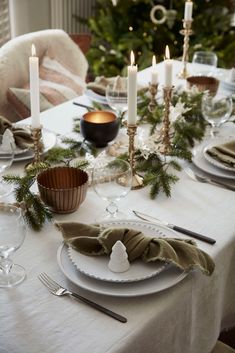 a table set for christmas dinner with candles