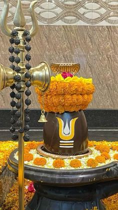 an elaborately decorated fountain with flowers and candles on it's sides in front of a wall