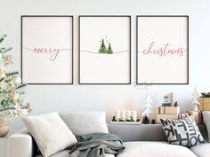 three christmas cards hanging on the wall in a living room with a couch and coffee table