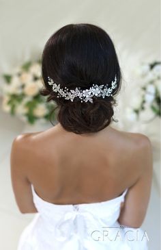 the back of a bride's head wearing a bridal hair comb with flowers on it