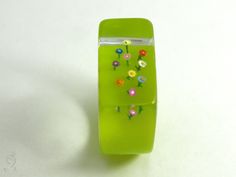 "NOW IT IS GETTING COLORFUL! A lovely, handmade unique for everyone who like it colorful. On a flashy green ring grow ten colorful mini-flowers up to the sky. The ring is very light and despite of the size extremely good to wear. Moreover it is a hand charmer and always an eye-catcher. SIZE/DIMENSIONS/WEIGHT This ring will be produced suitable for you (I need about three weeks for the production). Please specify your ring size (you can measure the inner diameter of a matching, wider ring). about Flower-shaped Plastic Jewelry As Gift, Flower Shaped Plastic Jewelry As Gift, Whimsical Green Flower Jewelry, Handmade Cute Green Ring, Flower-shaped Plastic Jewelry Gift, Handmade Cute Green Rings, Plastic Flower-shaped Jewelry For Gifts, Unique Green Resin Ring, Plastic Flower-shaped Jewelry As A Gift