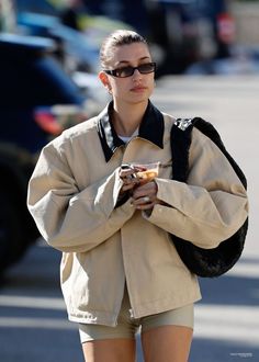 a woman walking down the street with her hand on her hip