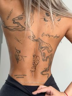 the back of a woman's body with tattoos on her upper and lower back