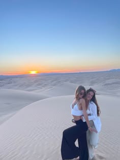 two girls at dan dunes at sunrise posing for the photo. one girl wears a while crochet top with float brown pants and the other wears a white button up Imperial Sand Dunes Photoshoot, Sand Dune Outfits, Hiking Trip Outfit, Sand Dunes Aesthetic, Sand Dunes Outfit, Senior Pic Outfit Ideas, Film Photo Ideas, Imperial Sand Dunes, Dunes Photoshoot