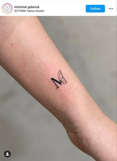 a small tattoo on the arm of a woman with a butterfly in her left hand