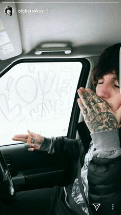 a woman sitting in the back seat of a car with her hand on her face