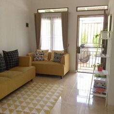 a living room with two couches and a rug in front of the sliding glass door