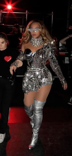 two women dressed in silver and black outfits