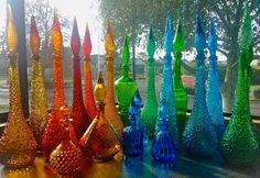 there are many different colored vases on the table