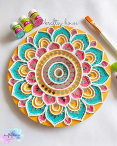 a paper doily with paint and crayons next to it