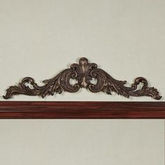 an ornately carved wooden mantle with white walls in the background