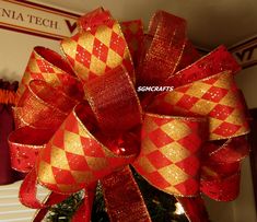 a red and gold bow on top of a christmas tree