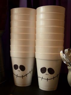 two white cups with faces painted on them