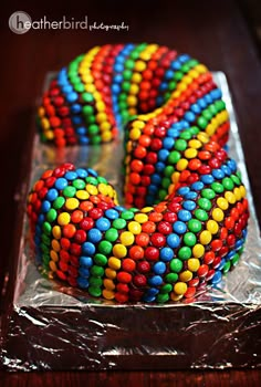 there is a cake decorated with multi colored candy beads on it's icing