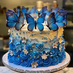 a blue and white cake with butterflies on top