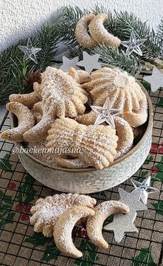 a bowl filled with powdered sugar stars and crescents on top of a table