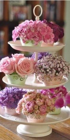 three tiered cake stand with flowers on it