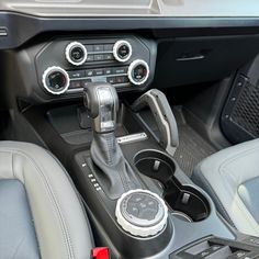 the interior of a car with an automatic gear box and steering wheel control knobs