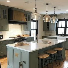 a large kitchen with an island in the middle and three stools next to it