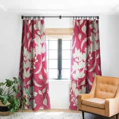 a living room with a chair, window and potted plant in front of it