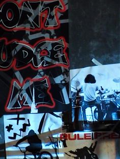 some graffiti on the side of a building with people playing drums and drummers in it