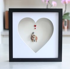 a heart shaped frame with a teddy bear in the middle and a small stuffed animal inside