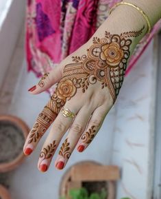 a woman's hand with henna tattoos on it