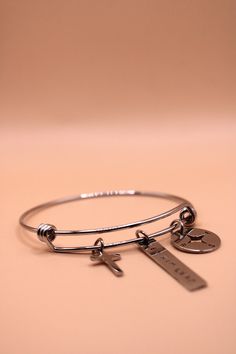 To celebrate Stamped by Sis making 3 years, this piece serves as a reminder to embrace faith and let the guiding hand of Christ lead your path. Made from durable stainless steel, this adjustable bangle features an elegant hand-stamped inscription, a symbol of your devotion and trust in God's plan included with a Cross and Compass Charm! Handmade Adjustable Bangle Charms: Cross, Bar & Compass Metal: Stainless Steel Silver How to Care for Your Jewelry: This item can get wet. However, ink may wear Adjustable Stainless Steel Bangle Charm Bracelet, Adjustable Nickel-free Stainless Steel Bangle, Adjustable Stainless Steel Nickel-free Bangle, Adjustable Engraved Stainless Steel Bangle, Inspirational Adjustable Silver Charm Bracelet, Cross Bar, Virtual Hug, God's Plan, Adjustable Bangle