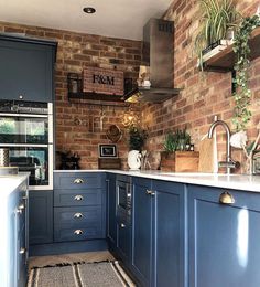 a kitchen with blue cabinets and brick walls