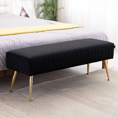 a black bench sitting on top of a bed