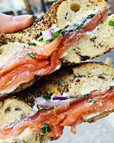 a person holding up a sandwich with meat and cheese