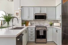 a kitchen with white cabinets and stainless steel appliances