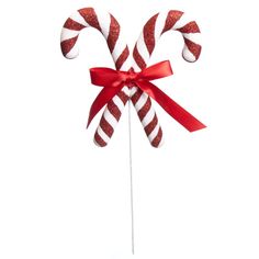 red and white candy canes tied together with a red ribbon on a white background