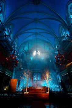 the interior of an old church lit up with blue lights and trees on either side