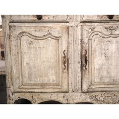 an old white cabinet with ornate carvings on the doors